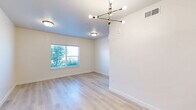 Located at 231 W 12th St in Ogden, Utah, this thoughtfully designed 2-bedroom, 1-bathroom residence offers a clean, modern aesthetic across a single level. The open-concept kitchen and living area serves as the heart of the home, featuring light wood-style flooring, white shaker cabinetry, quartz countertops, stainless steel appliances — including a refrigerator, range, microwave, and dishwasher — and a peninsula that provides additional prep and dining space. Recessed lighting illuminates the kitchen, while a stylish multi-arm brass chandelier accents the living area.

Both bedrooms are carpeted for comfort and receive natural light through large windows with views of the surrounding neighborhood. The primary bedroom includes convenient access to the full bathroom and a dedicated closet. The bathroom is finished with large-format tile flooring, a quartz-topped vanity with shaker-style cabinetry, and a full tub/shower combination. Crisp white walls and clean-lined panel doors are consistent throughout, contributing to a cohesive, contemporary feel. A hallway connects the main living spaces to the bedrooms, maintaining a practical and efficient layout.