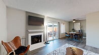 Located in the Greenhaven neighborhood of Sacramento, CA, this single-story 2-bedroom, 2-bathroom home offers a well-designed layout with modern finishes throughout. The living room features durable wood-look flooring, a classic fireplace with a clean white surround, and a welcoming entryway. Adjacent to the living room, the dining area is highlighted by a ceiling fan, a sliding window with outdoor views, and warm wood-toned flooring that enhances the inviting atmosphere. The galley-style kitchen is outfitted with slate-gray shaker cabinetry, white countertops, stainless steel appliances including a refrigerator, dishwasher, and range, and light wood-look flooring that ties the space together. The primary bedroom offers plush carpeting, a window overlooking lush greenery, and a textured ceiling. The second bedroom is bright and carpeted with natural light filtering through a window. Both bathrooms are finished in crisp white tones — one features a walk-in shower with a rain showerhead, glass sliding doors, and built-in wood shelving, while the second includes a shower/tub combo with sliding glass doors and a gray vanity with a white countertop. A hallway and closet complete this efficiently laid-out home.