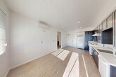 Located at 171 Siesta Way in Sonoma, CA, this efficiently designed one-bedroom, one-bathroom residence offers a thoughtful layout across a single floor. The open-concept main area seamlessly combines the living, dining, and kitchen zones, creating a versatile and functional living space. Light wood-look flooring runs throughout, complementing the bright white walls and recessed lighting that keep the interior feeling clean and contemporary. A wall-mounted mini-split air conditioning unit provides climate control in the main living area.

The kitchen is outfitted with dark shaker-style cabinetry extending to the ceiling for ample storage, white countertops, a single-basin sink, and white appliances including a refrigerator and range with overhead ventilation. A sliding glass door in the living area allows natural light to pour in, casting a warm glow across the space.

The bedroom is a well-proportioned, sun-filled room featuring a window with outdoor views and a set of sliding closet doors that maximize usable floor space. The bathroom is cleanly finished with wood-look flooring, a dark vanity, and accessibility-friendly grab bars. A hallway connects the rooms, and two closets provide additional storage throughout the residence.