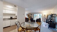 This well-appointed one-bedroom, one-bathroom residence in Fairview Park, Ohio offers a thoughtfully organized single-floor layout that maximizes functionality and comfort. The open living and dining area serves as the heart of the home, featuring plush carpeting, a textured ceiling, and a large sliding glass door that fills the space with natural light and provides access to a private balcony with outdoor views. The dining area accommodates a full-sized table, flowing seamlessly into the carpeted living room — an ideal setup for everyday living and entertaining. The kitchen is efficiently designed with white cabinetry, dark countertops, hardwood-style flooring, and includes a dishwasher and ample storage. A dedicated office with its own sliding glass door and garden views offers a bright, functional workspace. The bedroom is a comfortable, carpeted retreat featuring a full closet with bi-fold doors and a window that brings in soft natural light. The bathroom is finished with white tile, a vanity with storage, and hardwood-style flooring that extends into the connecting hallway. Clean neutral tones and practical finishes throughout lend the space a calm, move-in-ready ambiance.