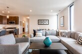Located in Woodbridge, NJ, this contemporary single-floor residence offers a thoughtfully designed layout with modern finishes throughout. The open-concept living and dining area is bright and spacious, featuring light hardwood flooring, recessed lighting, and a row of tall, narrow windows that flood the space with natural light and offer open exterior views. The living area accommodates a generous sectional sofa arrangement alongside a dedicated dining space.

The kitchen is well-appointed with rich dark cabinetry, white quartz countertops, a classic subway tile backsplash, and a full suite of stainless steel appliances including a refrigerator, gas range, microwave, and dishwasher. A kitchen island provides additional prep and dining space.

The bedrooms feature plush carpeting, ample closet storage, and tall narrow windows that bring in natural light. The primary bedroom benefits from corner window placement, offering views of the surrounding area. A secondary room with carpeted floors serves well as a bedroom, home office, or flex space.

The bathrooms are finished with large-format tile flooring, dark wood vanities with white countertops, and clean, neutral walls. Recessed and vanity lighting complete each bathroom's polished look. This residence combines functional design with a clean, modern aesthetic.