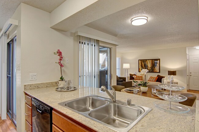 A kitchen with light cabinets and black appliances - Motif