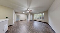 Located at 12433 Admiralty Way in Everett, WA, this one-bedroom, one-bathroom unit offers a thoughtfully designed single-floor layout that makes excellent use of its space. The living room features rich wood-style plank flooring, a ceiling fan, and large windows that invite natural light and offer pleasant views of the surrounding greenery, creating a bright and welcoming atmosphere. The galley-style kitchen is well-appointed with gray shaker cabinetry, white countertops, wood-style flooring, and a full suite of black and stainless steel appliances including a range, built-in microwave, refrigerator, and dishwasher. A dedicated closet provides convenient storage. The bedroom is carpeted for comfort, equipped with a ceiling fan, and features a window overlooking lush outdoor foliage, lending a serene, nature-connected feel. The bathroom includes a full tub-shower combination with grab bars and wood-style flooring, rounding out the practical amenities of the unit. Neutral tones throughout the home create a clean, versatile backdrop, while the consistent use of wood-style flooring in the main living areas ties the space together cohesively.