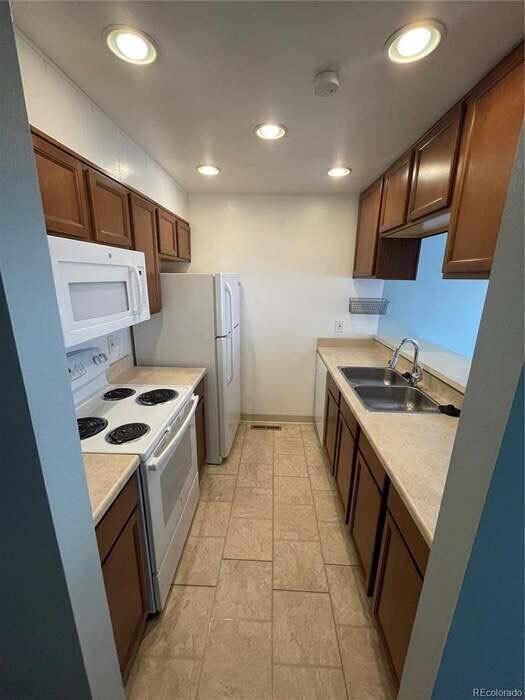 Kitchen that overlooks into the dining room with a bay window with shelves for plants. - 6700 E Mississippi Ave