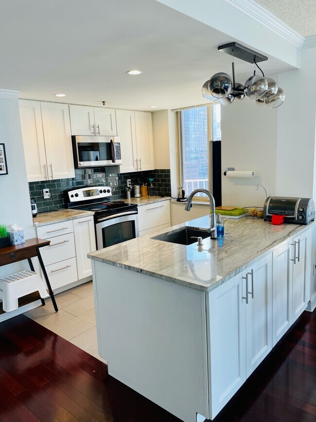 Renovated Kitchen with Granite countertop and open to living room and window in kitchen - 1 2ND St