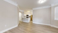 This well-appointed single-story home offers a thoughtfully designed layout across five bedrooms, one full bathroom, and multiple living areas, providing generous space for a variety of living arrangements. Light wood-style flooring and neutral warm tones flow consistently throughout, creating a cohesive and bright interior aesthetic complemented by white crown molding.

The open-concept kitchen serves as a central hub, featuring white shaker-style cabinetry, light stone countertops, a peninsula with integrated sink and dishwasher, and a full suite of stainless steel appliances including a range, over-the-range microwave, and refrigerator. The kitchen opens naturally into the adjoining living and dining areas, enhancing the sense of connectivity and flow.

Two living rooms offer flexibility for entertaining or everyday use, each featuring the same light flooring and neutral palette. Ceiling fans with lighting fixtures appear in several rooms, and multiple windows dressed with horizontal blinds allow ample natural light to fill the interiors.

The five bedrooms vary in size, with the primary bedroom offering notably generous proportions. Each room is finished with the same consistent flooring and neutral wall tones. The full bathroom is clean and functional, with a tub-shower combination, white vanity, and coordinating brushed nickel fixtures. A dedicated laundry room houses a full-size washer and dryer with overhead shelving and direct garage access.