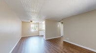Located at 501 Greenfield Drive in El Cajon, California, this single-story 2-bedroom, 1-bathroom home offers a practical and comfortable layout. The open living area features warm wood-look laminate flooring, neutral beige walls, and a textured ceiling with a ceiling fan, creating a bright and inviting atmosphere. Natural light flows in through windows fitted with vertical blinds, enhancing the spacious feel of the main living space.

The galley-style kitchen is well-appointed with crisp white cabinetry, granite-look countertops, a double-basin sink, and white appliances including a refrigerator and range. Wood-look flooring continues throughout the kitchen, maintaining a cohesive aesthetic.

Both bedrooms are carpeted for comfort and feature ceiling fans. The primary bedroom includes a sliding glass door that opens to a private outdoor patio with greenery views, while the second bedroom offers a sliding closet with built-in shelving and a window with vertical blinds. An additional room features wood-look flooring and a wall-mounted air conditioning unit.

The bathroom is clean and functional, featuring a full tub-shower combination with chrome fixtures and a window above for natural ventilation. Throughout the home, white baseboards and a consistent neutral palette provide a tidy, move-in-ready appeal.
