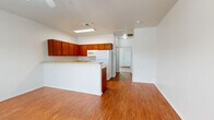 Located at 2722 Frankford Ave in Lubbock, TX, this single-floor unit offers a well-organized layout that makes efficient use of its space. The combined kitchen and living area forms the heart of the home, featuring warm hardwood-look flooring that extends throughout the main living spaces. The kitchen is equipped with rich, warm-toned wood cabinetry that wraps around the perimeter, offering generous storage. Light countertops provide ample workspace, complemented by a double-basin sink, a dishwasher, a range, a built-in microwave, and a full-size refrigerator. A raised breakfast bar peninsula defines the boundary between the kitchen and the living area, creating a natural flow between the two spaces. The living area benefits from a front-facing window dressed with blinds, allowing natural light to brighten the room. The bedroom is a comfortable, well-proportioned space finished with soft carpeting underfoot and a ceiling fan overhead. A window with blinds lets in natural light while maintaining privacy. The bedroom features access to a dedicated walk-in closet, providing practical storage. Clean white walls and crisp trim throughout the unit create a bright, neutral backdrop well-suited for a variety of furnishing styles.