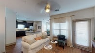Located at Shadow Creek Pkwy in Pearland, TX, this single-floor residence offers a thoughtfully designed layout that blends comfort and modern style. The open-concept living and dining area is bright and welcoming, featuring warm hardwood-style flooring, ceiling fans, and large windows dressed with sheer curtains and blinds that invite abundant natural light. A private door off the living area provides convenient outdoor access.

The kitchen is a standout space, boasting rich dark cabinetry, granite countertops, a tile backsplash, and a full suite of stainless steel appliances including a French door refrigerator, range, microwave, and dishwasher. The dining area, positioned near a large window, comfortably accommodates a round table setting.

The bedrooms offer a calm, restful atmosphere with plush carpeting, ceiling fans, and generous natural light. The primary bedroom features an elegant tufted headboard accent and walk-in closet access. The primary bathroom includes a long vanity with granite countertops and dark cabinetry, tile flooring, and a separate water closet. A secondary bathroom provides a tub-shower combination with tile surround. Throughout, the space maintains a cohesive, contemporary aesthetic with neutral tones and carefully selected design details.