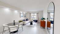 Located at 1355 W 44th Pl in Hialeah, FL, this thoughtfully renovated single-floor residence offers a clean, contemporary aesthetic throughout its well-organized layout. The open-concept living and dining area serves as the heart of the home, bathed in natural light streaming through a sliding glass door that opens to an outdoor view. Light-toned large-format tile flooring runs consistently across the space, enhancing the sense of openness and continuity. Recessed lighting and neutral warm-white walls create a bright, welcoming ambiance.

The galley-style kitchen is efficiently designed with floor-to-ceiling white shaker cabinetry, quartz countertops, a classic subway tile backsplash, and stainless steel appliances, including a full-size refrigerator and range. A window above the sink brings in natural light, making the space feel airy despite its streamlined footprint.

The primary bedroom is a serene retreat featuring recessed accent lighting, a broad window with privacy blinds, and light hardwood-style flooring. A second bedroom accommodates twin beds and benefits from its own window, making it a versatile space for guests or shared occupancy. The bathroom is finished with glossy white subway tile in the walk-in shower, mosaic tile flooring, and a sleek gold-tone fixtures, delivering a polished, modern feel.