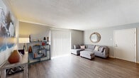 Located at 304 Enchanted Pkwy in Manchester, Missouri, this single-floor unit offers a thoughtfully arranged layout that balances open communal spaces with private retreats. The living room is generously proportioned, featuring light wood-style flooring, neutral gray walls, and a sliding glass door with vertical blinds that fills the space with natural light. A dedicated hallway connects the living area to the rest of the unit, maintaining a clear sense of flow throughout.

The dining area sits adjacent to the kitchen and is highlighted by a ceiling fan with integrated lighting. The kitchen is efficiently designed with white cabinetry, light countertops, a stainless steel sink, and a full suite of appliances including a stainless electric range with over-the-range microwave, dishwasher, and refrigerator. Wood-style flooring continues through this area.

Two bedrooms provide comfortable retreats, each carpeted and featuring windows that allow natural light. The bathroom is clean and functional, outfitted with a white vanity, mirrored medicine cabinet, and wood-style tile flooring. Textured ceilings are consistent throughout the unit, contributing to a cohesive and neutral overall aesthetic.