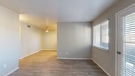 Located at 1640 W Bunbury Ln in Salt Lake City, Utah, this single-story unit presents a clean, neutral aesthetic throughout its thoughtfully arranged layout. The living areas feature wood-look plank flooring in warm and cool gray tones, complemented by soft gray walls and white baseboards that create a bright, cohesive feel. Natural light enters through blinded windows, enhancing the open character of the connected living and dining areas, which flow smoothly from one to the next beneath a ceiling-mounted light fixture.

The galley-style kitchen is efficiently designed with white shaker cabinetry lining both sides, light countertops, an undermount sink, and wood-look flooring that ties it to the main living space. A window above the counter allows natural light in, and the kitchen is equipped with a full-size refrigerator and dishwasher.

The bedrooms are carpeted and finished in the same soft neutral palette, each featuring windows with outdoor views and ample wall space. One bedroom includes a spacious walk-in closet outfitted with built-in shelving and dual hanging rods, providing generous storage. An additional entry area with a door and adjacent window offers a practical transition into the main living space, completing this well-organized single-floor residence.