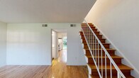 Located at 2101 Gorman St in Raleigh, NC, this two-story home offers a well-organized layout split evenly across two floors. Warm hardwood flooring flows throughout the main living areas and bedrooms, complemented by rich slate-style tile in the kitchen and bathrooms, creating a clean contrast of materials.

The main floor opens into a bright living room with natural light streaming through large windows that overlook greenery outside. A staircase with warm wood treads and white balusters connects both levels. The combined kitchen and dining area is equipped with white cabinetry, light countertops, a full suite of white appliances, and a window above the sink providing natural light. One bathroom on this floor doubles as a laundry room, housing a full-size washer and dryer alongside a vanity and toilet — a practical and space-efficient design.

Upstairs, two bedrooms offer comfortable proportions, with the spacious primary bedroom providing ample room for furnishings. Both bedrooms feature ceiling fans with light kits and natural light from windows. Closets are plentiful throughout, with four total across the home. A clean, bright full bathroom with a tub-shower combo, white vanity, and slate tile flooring serves the upper level. Utility needs are addressed by a dedicated mechanical room housing the HVAC system and water heater.