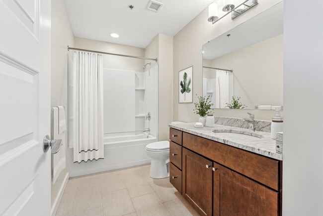 Spacious apartment bathroom with double-sink vanity and upscale finishes - Voke Lofts