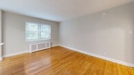 Located at 214 Price Ave in the walkable borough of Narberth, PA, this one-bedroom, one-bathroom residence offers a well-considered layout across a single floor. The living room is entered through a distinctive arched doorway — a standout architectural detail that lends classic character to the space. Natural light filters in through multiple windows fitted with blinds, illuminating warm-toned hardwood floors that flow throughout the main living and bedroom areas. A radiator cover beneath the living room window adds a traditional touch, while neutral gray walls provide a clean, versatile backdrop.

The kitchen has been thoughtfully renovated and features a galley-style configuration with contemporary two-tone cabinetry in a natural wood finish, white quartz countertops, light porcelain tile flooring, and a full suite of stainless steel appliances including a gas range, microwave, and refrigerator. A skylight overhead enhances the sense of brightness in this efficiently arranged space.

The bedroom is a well-proportioned retreat equipped with a ceiling fan and closet, finished in the same hardwood flooring and neutral palette found throughout. The bathroom is cleanly updated with a glass-enclosed walk-in shower, tile surround, modern vanity, and a window that introduces natural light. Overall, the residence combines classic architectural details with modern updates for a comfortable and cohesive living environment.