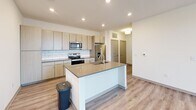 Located at 2311 Odell School Rd in Charlotte, NC, this well-designed single-story home offers three bedrooms and two bathrooms across a thoughtfully laid-out floor plan. Light wood-look flooring flows through the main living areas, complementing the clean, neutral palette found throughout.

The open-concept kitchen is a standout feature, equipped with stainless steel appliances including a range, microwave, and refrigerator, along with light wood cabinetry, a white subway tile backsplash, and a center island with an undermount sink and quartz-style countertops — ideal for both cooking and entertaining. The adjoining living room is bright and airy, featuring recessed lighting, a ceiling fan, and a door that opens to an outdoor area, filling the space with natural light.

The primary bedroom includes an en-suite bathroom outfitted with a glass-enclosed walk-in shower, a modern vanity with ample storage, and wood-toned cabinetry. A spacious walk-in closet with built-in shelving and hanging rods provides generous storage. The second bathroom features a soaking tub with a tiled surround and a matching vanity. The secondary bedrooms are carpeted, bright, and well-proportioned, with large windows offering pleasant outdoor views.