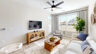 Located at 3145 Prado Ln in Charlotte, NC, this well-appointed single-floor residence offers a thoughtful layout across a comfortable footprint. The open-concept living and kitchen area serves as the heart of the home, bathed in natural light from large windows dressed with linen drapes. Ceiling fans overhead and light wood-look flooring throughout lend a clean, airy feel to the space.

The kitchen is outfitted with crisp white shaker cabinets, herringbone tile backsplash, dark countertops, and a full suite of stainless steel appliances, including a side-by-side refrigerator, electric range, and microwave. The living area flows seamlessly from the kitchen, providing an inviting space for relaxing or entertaining, with direct access to a private patio.

The bedroom is a comfortable retreat, featuring a ceiling fan, plush carpeting, and a generous walk-in closet complete with built-in shelving and hanging rods for ample storage. A dedicated hallway connects the key areas of the home.

The bathroom is finished with white subway tile surrounding the tub-shower combo, a single-sink vanity with dark stone countertop, white cabinetry, and wood-look flooring. A separate laundry area adds everyday convenience, completing this efficiently designed Charlotte residence.