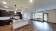This single-story, 2-bedroom, 2-bathroom residence in Houston, TX (77045) offers a well-designed open-concept layout that seamlessly connects the kitchen, dining, and living areas. The kitchen is a standout feature, showcasing dark espresso cabinetry, granite countertops, a subway tile backsplash, and a full suite of stainless steel appliances, including a side-by-side refrigerator, electric range, and built-in microwave. A central island with an undermount sink and pendant lighting above adds both functionality and style. Rich wood-style flooring flows throughout the main living areas, complementing the neutral wall tones and recessed lighting. The spacious living area benefits from multiple windows that invite natural light and a ceiling fan for added comfort. Both bedrooms are carpeted and include ceiling fans and windows with exterior views. Each bathroom features dark cabinetry with granite countertops, and at least one bathroom offers a double-sink vanity and a full soaking tub. A walk-in closet with built-in shelving is accessible from one of the bathrooms, providing generous storage. The overall design balances contemporary finishes with a functional, comfortable floor plan.