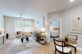 Located at 2000 James Jackson Pkwy in Atlanta, GA, this thoughtfully designed 2-bedroom, 2-bathroom residence offers a cohesive open-concept layout that seamlessly connects the kitchen, dining, and living areas. Light hardwood-style flooring flows throughout the main living spaces, complemented by soft neutral walls and abundant natural light from multiple windows. The kitchen is a standout feature, boasting warm wood cabinetry, crisp white quartz countertops, a spacious island with bar seating, stainless steel appliances, and stylish pendant lighting — equally suited for everyday cooking and entertaining. The dining area sits adjacent, accommodating both casual and formal settings. The living room is generously proportioned, with a ceiling fan and windows that invite natural light. A hallway leads to both bedrooms, each featuring plush carpet, ceiling fans, and windows with views of the outdoors. The primary bedroom offers a comfortable, serene retreat. Two full bathrooms are finished with wood-tone vanities, white countertops, and clean tile work, with one featuring a soaking tub. Two closets, including a walk-in with wire shelving, provide ample storage throughout this well-planned Atlanta residence.