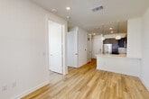 Located at 3112 Leeland St in Houston, TX, this efficiently designed one-bedroom, one-bathroom unit delivers a modern aesthetic across a single floor. Light wood-style flooring runs throughout the entire space, creating a cohesive and clean look from room to room.

The open-concept kitchen flows seamlessly into the combined dining and living area, making the layout feel airy and connected. The kitchen is equipped with a full suite of stainless steel appliances — including a refrigerator, electric range, over-the-range microwave, and dishwasher — complemented by rich dark-wood cabinetry, white quartz countertops, a peninsula with an undermount sink, and stylish globe pendant lighting. A bright entrance leads naturally into this central living zone, which benefits from a front-facing door and a ceiling fan overhead.

The bedroom is bathed in natural light from multiple large windows with views to the outdoors, and includes a ceiling fan for comfort. Two closets provide generous storage, including a well-organized walk-in closet with built-in shelving and hanging rods.

The bathroom features a glass-enclosed walk-in shower with marble-style tile, a floating dark-wood vanity with a white countertop, and wood-look flooring. A dedicated utility and laundry room rounds out the functional layout of this well-appointed Houston residence.