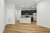 This single-story, one-bedroom, one-bathroom unit offers a thoughtfully designed layout that maximizes functionality and comfort. The open-concept living and kitchen area forms the heart of the space, featuring light wood-style flooring, recessed lighting, and a ceiling fan that enhances airflow throughout. The kitchen is well-equipped with dark espresso cabinetry, granite-style countertops, a full suite of stainless steel appliances including a refrigerator, electric range, and microwave, and a curved kitchen island with an integrated sink — ideal for both cooking and casual dining. The living area receives natural light through a large window and a glass-paneled exterior door that opens to an outdoor area.

The bedroom is generously sized, finished with plush carpet and a ceiling fan, and benefits from natural light via a window with blinds. A spacious walk-in closet with wire shelving provides ample storage. The bathroom features dark cabinetry, a granite-topped vanity, a linen tower, and a full tub/shower combination, all set on wood-style flooring. A dedicated hallway and entrance complete the layout, offering a clean and organized flow throughout the unit.