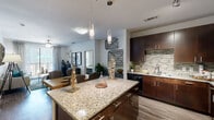 Located at 8910 Southwestern Blvd in Dallas, TX, this single-story residence at Home at Avery showcases a thoughtfully designed open-concept layout that seamlessly connects the kitchen, dining, and living areas. The kitchen is a standout feature, boasting rich dark espresso cabinetry that extends to the ceiling, a striking granite-topped center island illuminated by sleek cylindrical pendant lights, a mosaic tile backsplash, and a full suite of stainless steel appliances including a refrigerator, electric range, and microwave. Track lighting enhances the workspace, while wood-look flooring ties the space together. The living area is bright and welcoming, featuring a ceiling fan, large sliding glass doors that invite natural light and outdoor views, and stylish flooring throughout. The bedrooms offer plush carpeting, ceiling fans, and generous natural light from well-framed windows, creating a comfortable and restful retreat. The primary bathroom is generously proportioned, featuring a glass-enclosed walk-in shower, a separate soaking tub, a long dark vanity with a broad mirror, and clean tile flooring. Every detail of this residence reflects a modern, contemporary aesthetic designed for comfortable everyday living.