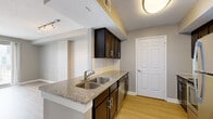 Located in the heart of Nashville, TN, this one-bedroom, one-bathroom residence on Church Street offers a thoughtfully designed single-floor layout with modern finishes throughout. Light-toned hardwood-style flooring flows seamlessly across the living areas, complemented by neutral gray walls and white trim that create a clean, contemporary aesthetic.

The combined kitchen and living area serves as the central hub of the home. The kitchen features dark espresso cabinetry with sleek hardware, granite countertops, a subway tile backsplash, a double-basin sink set into a peninsula, and a full suite of stainless steel appliances. The open peninsula design connects the kitchen to the living area, making the space feel open and well-suited for everyday living.

The spacious primary bedroom receives natural light through a window with city views and includes access to a private balcony with sliding glass doors that frame sweeping Nashville skyline views. A dedicated closet and a connecting hallway provide practical storage and circulation throughout the unit.

The bathroom is finished consistently with the rest of the home, featuring granite countertops, dark cabinetry, a tub-shower combination, and wood-style flooring. A hallway with additional closet space completes the layout, offering functional utility in a compact but efficient floor plan.
