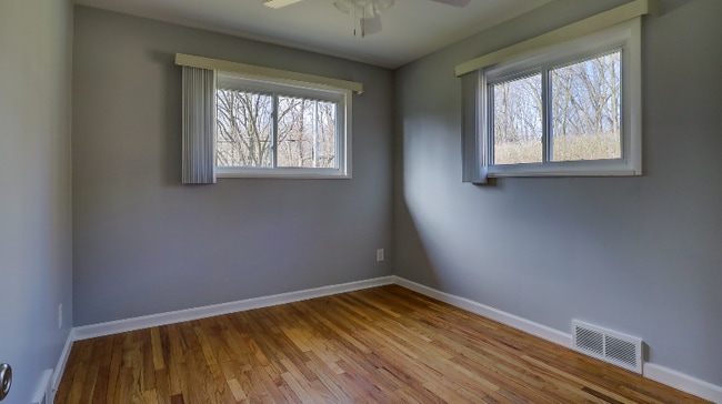 1 of 2 bedrooms with hardwood floors and ceiling fans - 717 Newport Pl