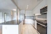Located at 74 Curlew Dr in Toronto's M3A neighbourhood, this one-bedroom, one-bathroom unit offers a well-designed layout across a single floor. The open-concept kitchen and living area form the heart of the space, where a peninsula with a dark countertop provides a natural divide between the two zones. The kitchen is outfitted with white cabinetry, a herringbone tile backsplash, stainless steel appliances including a refrigerator, dishwasher, and range, and light tile flooring that contrasts with the warm parquet found throughout the rest of the unit. The living room is generously proportioned, featuring a wide bank of windows that invite ample natural light and offer views of surrounding greenery. A distinctive textured ceiling adds architectural character to this area. The bedroom is a comfortable size, complete with mirrored sliding closet doors, a window overlooking the outdoors, and baseboard heating. The bathroom is finished with classic white subway tile surrounding a full bathtub with an overhead shower, complemented by clean chrome fixtures. Consistent parquet flooring throughout the main living spaces ties the unit together with a timeless, cohesive aesthetic.