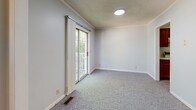 Located at 707 S Washington St in Warrensburg, Missouri, this 2-bedroom, 1-bathroom unit offers a practical and well-organized single-floor layout. The living room is bright and open, featuring soft carpet flooring, light gray walls, a textured ceiling, and a sliding glass door that leads to a private balcony with outdoor views — allowing natural light to fill the space throughout the day.

The galley-style kitchen is efficiently designed with ample warm-toned wood cabinetry lining both walls, light countertops, a double-basin sink, a dishwasher, and an electric range with overhead ventilation. The kitchen features easy-care wood-look flooring, providing a clean contrast to the carpeted living areas.

Both bedrooms are carpeted and feature the same soft gray walls and textured ceilings found throughout the unit. The primary bedroom is generously sized, offering a walk-in closet for added storage. The second bedroom includes a standard closet with bifold doors. Each bedroom benefits from natural light through windows with outdoor greenery views.

The bathroom is clean and straightforward, featuring a full tub-shower combination in a bright white surround. A connecting hallway ties the layout together, creating a cohesive flow between all rooms. This unit offers a functional and comfortable living environment in a convenient Warrensburg location.