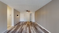 Located at 4314 Dresden St in Columbus, Ohio, this single-floor unit offers a well-organized layout with thoughtfully updated interiors throughout. The main living area features rich, wood-look luxury vinyl plank flooring in a cool gray-toned finish, complemented by neutral gray walls, white baseboards, a textured ceiling, and a ceiling fan with integrated lighting. A sliding glass door fills the space with natural light and provides access to an outdoor area. An additional room with similar flooring and a ceiling fan includes a built-in closet and entry door, offering flexible use as a bedroom or secondary living space. The kitchen is equipped with white cabinetry, granite-style countertops, and black appliances including a range, over-the-range microwave, and refrigerator. Bedroom spaces feature plush carpeting and large windows that invite natural light and outdoor views. Storage is well addressed with closets throughout, including a spacious walk-in closet with built-in shelving and carpeted flooring. Two bathrooms are present: a full bath with a tub/shower combo, granite-top vanity, and wood-look flooring, and a half bath with a matching vanity and consistent flooring. The overall aesthetic is clean, modern, and move-in ready.