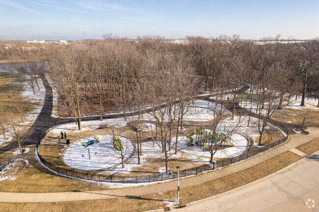 Arbor Park in Waukegan has multiple playgrounds and a paved walking trail in a wooded setting.