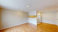 Located at 1901 Montecito Avenue in Mountain View, California, this well-appointed one-bedroom, one-bathroom unit offers a thoughtfully designed single-floor layout. Warm-toned hardwood flooring runs throughout the living spaces, complementing the neutral beige walls and crisp white trim that give the unit a clean, cohesive aesthetic.

The living room serves as the heart of the unit, featuring recessed lighting, crown molding, and a large window with vertical blinds that invites natural light and outdoor views. A front entry door with a decorative half-moon window provides an inviting welcome. The open-concept layout connects the living and dining areas seamlessly, with a half-wall peninsula separating them from the kitchen.

The kitchen features white cabinetry, tile countertops, a stainless steel sink, tile flooring, and a full-size refrigerator, providing practical functionality in a compact footprint. Three closets throughout the unit offer generous storage options.

The bedroom is a comfortable, well-proportioned space with hardwood floors, crown molding, and a window that brings in natural light and views of the surrounding greenery. The bathroom is finished in an all-white palette with tile flooring, a vanity with storage, and a full tub-shower combination with tiled surround, offering a clean and functional design.