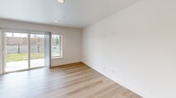 This well-appointed two-story home in Richland, WA offers three bedrooms and three bathrooms across two thoughtfully designed floors. The main level features an open-concept kitchen and living area with light hardwood-style flooring and recessed lighting throughout. The kitchen is outfitted with dark cabinetry, a crisp white countertop, and a full suite of stainless steel appliances including a refrigerator, range, microwave, and dishwasher. A sliding glass door opens from the living area to a covered patio and a fenced backyard with a grassy lawn enclosed by wrought iron fencing and a surrounding block wall, offering a private outdoor retreat. Upstairs, the three bedrooms are finished with plush carpet and feature windows that invite natural light. The primary bedroom includes a sliding closet and direct access to an en-suite bathroom. The additional bedrooms are well-sized with ample wall space and window views. All three bathrooms are clean and bright, featuring tub-shower combinations with white surrounds and brushed nickel fixtures. A hallway and staircase connect the two levels, completing this functional and modern home.