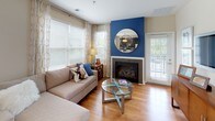This thoughtfully designed single-floor residence combines modern finishes with a cohesive navy blue and neutral color palette throughout. The living room is a welcoming focal point, featuring warm hardwood flooring, abundant natural light from multiple windows dressed with patterned curtains, and a striking fireplace set against a bold blue accent wall. The open layout allows for a seamless flow into the dining area, which benefits from a large window overlooking lush greenery outside.

The kitchen is well-equipped for everyday cooking and entertaining, showcasing dark espresso cabinetry, stainless steel appliances including a refrigerator, range, microwave, and dishwasher, along with granite countertops and a peninsula island with bar seating — ideal for casual dining or prepping meals.

The primary bedroom offers plush carpeting, a dedicated walk-in closet with built-in shelving, and a calm, restful atmosphere. The secondary bedroom is equally inviting, with soft carpeting, ample natural light, and generous wall space. Both bathrooms are finished with dark cabinetry, granite vanity tops, tile flooring, and tiled tub-shower combinations accented with decorative mosaic tile borders, delivering a clean and polished look throughout.