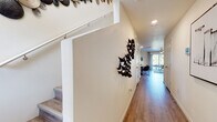 This two-story home offers a thoughtfully designed layout with modern finishes and a warm, welcoming ambiance. The entryway greets visitors with light wood-look flooring that carries throughout the main level, a staircase leading to the upper floor, and decorative wall art that sets a contemporary tone.

The open-concept kitchen is a standout feature, equipped with white shaker cabinetry, granite countertops, stainless steel appliances including a range, microwave, dishwasher, and refrigerator, and a peninsula with an undermount sink — ideal for both cooking and casual dining. Recessed lighting and a textured ceiling complete the space.

Adjacent to the kitchen, the living area is bright and comfortable, featuring a ceiling fan, large sliding glass doors that open to a private outdoor patio, and windows that bring in generous natural light and views of the surrounding greenery.

The dedicated dining area accommodates a round table and chairs, framed by clean white walls and contemporary artwork. Bedrooms are well-sized, featuring ceiling fans, ample closet space, and windows with outdoor views that fill each room with natural light. The bathroom is clean and functional, with a granite-topped vanity, wood-look flooring, and a walk-in glass-door shower.