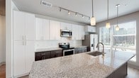Located at 2312 Bristol Creek Dr in Morrisville, NC, this single-floor residence offers a thoughtfully designed layout with modern finishes throughout. The kitchen is a standout feature, showcasing a two-tone cabinet design with crisp white upper cabinets and dark espresso lower cabinets, a classic white subway tile backsplash, stainless steel appliances, and an expansive granite island with an undermount sink and pendant lighting. Track lighting overhead ensures excellent task illumination throughout the space.

The living area is bright and welcoming, with light wood-look flooring, multiple large windows fitted with blinds, recessed lighting, and a ceiling fan that enhance both comfort and natural light. The bedrooms feature plush carpeting, ceiling fans, and generously sized windows that bring in outdoor views and ample daylight.

The primary bathroom is well-appointed with wood-look flooring, a double granite-topped vanity, a glass-enclosed walk-in shower with marble-style tile, and access to a walk-in closet. A second full bathroom offers a granite vanity and a tiled tub-shower combination. A dedicated in-unit laundry area with a full-size washer and dryer adds everyday convenience, completing this well-equipped and modern residence.