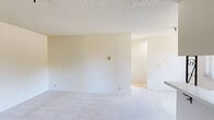 Located at 230 N Mathilda Ave in Sunnyvale, CA, this single-floor, one-bedroom, one-bathroom unit offers a practical and straightforward layout. The combined kitchen and living area forms the heart of the space, with the kitchen featuring white cabinetry, ample counter space, a refrigerator, a single-basin sink, and tile flooring. A flush ceiling light provides functional illumination. The living area is finished with light-toned carpet and textured ceilings, creating a clean, neutral backdrop. A separate dining area adjacent to the kitchen includes tile flooring and a ceiling fan with light, with windows offering views of the surrounding neighborhood. The bedroom is a well-proportioned room, carpeted throughout and filled with natural light from dual windows. Baseboard heating ensures comfort, and the lush greenery visible outside adds a pleasant outdoor connection. The bathroom is equipped with a wide vanity featuring a large mirror, under-sink cabinetry, tile flooring, and a separate shower area. Neutral tones are carried consistently throughout the unit, giving the space a clean and cohesive appearance well-suited for comfortable everyday living in the heart of Silicon Valley.