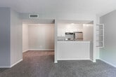 Located at 2159–2165 Godby Rd in College Park, GA, this single-story unit offers a practical and well-organized layout. The living area is generously proportioned, finished with plush carpeting and neutral-toned walls that create a calm, versatile backdrop. A sliding glass door with vertical blinds fills the space with natural light and provides outdoor access. The kitchen is connected to the living area via a pass-through counter with built-in shelving, making the layout feel open and communicative. Inside the kitchen, white cabinetry pairs with granite-look countertops and wood-style flooring, while stainless steel appliances—including a refrigerator, electric range, and dishwasher—add a modern touch. The bedrooms are carpeted and well-sized, with neutral walls and windows that bring in natural light. The bathroom features wood-style flooring, a granite-top vanity with gray cabinetry, a tiled tub-shower combination, and adequate storage space. Textured ceilings are consistent throughout the unit, contributing to the overall character of the space.