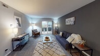 Located at 2006 W Algonquin Rd in Mount Prospect, IL, this single-floor residence offers a well-organized and comfortable layout designed for everyday living. The living room serves as the heart of the home, featuring plush carpeting, neutral-toned walls with a stylish charcoal accent wall, and a sliding glass door that opens to a private outdoor patio, filling the space with natural light and views of the surrounding greenery. The adjacent dining area is bright and functional, finished with tile flooring and a ceiling fan with integrated lighting, providing a welcoming space for meals. The kitchen is equipped with white cabinetry featuring decorative scalloped detailing, granite-style countertops, a stainless steel sink, and white appliances, along with an open display shelf that adds a charming, practical touch. The bedroom is generously sized, offering soft carpeting, a large window overlooking outdoor foliage, and ample closet space with bifold louvered doors. The bathroom is thoughtfully appointed with slate-style tile flooring, a dual-sink vanity with stone-look countertops, and a separate water closet housing a shower-tub combination. Together, these spaces create a cohesive, comfortable residence in a convenient Mount Prospect location.