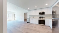 Located at The Skyline in West Sacramento, CA, this thoughtfully designed 4-bedroom, 2-bathroom residence offers a clean, modern aesthetic across a single level. Light-toned hardwood flooring runs seamlessly throughout, unifying every room and contributing to an airy, cohesive feel.

The open-concept kitchen and living area serves as the heart of the home. The kitchen is outfitted with full-height white flat-panel cabinetry, light countertops, a subway tile backsplash, and a complete suite of stainless steel appliances, including a refrigerator, range, microwave, and dishwasher. Recessed lighting illuminates the space with a clean, modern tone.

The four bedrooms are bright and well-proportioned, with neutral white walls and large windows that invite generous natural light. The spacious primary bedroom features a sliding door with outdoor access, flooding the room with sunlight and views of the surroundings. Bedrooms include closets with built-in wire shelving for practical storage.

The two bathrooms continue the home's minimalist palette, featuring white vanities with integrated sinks, large mirrors, brushed nickel fixtures, and hardwood-style flooring. One bathroom includes a full soaking tub, while the second offers a clean, functional layout. Together, these spaces reflect a cohesive, contemporary design ideal for modern living.