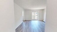 This well-appointed 2-bedroom, 1-bathroom unit at 49 McMurchy Ave N in Brampton offers a clean, modern aesthetic throughout its efficiently designed single-floor layout. The open living area is finished with light-toned vinyl plank flooring and crisp white walls, creating a bright and airy atmosphere. Sliding glass doors lead to a private balcony, allowing natural light to flood the space and providing outdoor access. The kitchen is thoughtfully updated, featuring white shaker-style cabinetry, dark countertops, a classic white subway tile backsplash, a stainless steel double sink, and stainless steel appliances including a dishwasher and electric range. Both bedrooms continue the consistent flooring and neutral palette, with the primary bedroom offering a comfortable footprint. Baseboard heating units are present in the bedrooms, ensuring year-round comfort. The bathroom is finished with floor-to-ceiling white subway tile surrounding a soaker tub with an overhead shower. A dedicated entrance and hallway provide a practical transition into the living areas. Throughout the unit, clean lines, white trim, and modern door hardware contribute to a cohesive, contemporary feel.