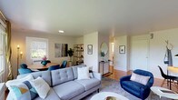 This single-floor residence offers a thoughtfully designed layout that balances comfort and style throughout. The open-concept living and dining area serves as the heart of the home, featuring warm hardwood flooring, crown molding, and an abundance of natural light streaming through large windows that frame lush green outdoor views. The living space accommodates a generous seating arrangement and flows seamlessly into a dedicated dining area, creating an ideal setting for both relaxing and entertaining.

The galley-style kitchen is both functional and refined, showcasing light gray shaker cabinetry with brass hardware, crisp white quartz countertops, classic subway tile backsplash, and a striking black-and-white octagonal tile floor. Stainless steel appliances complete the well-equipped space.

The two bedrooms are bright and serene, each benefiting from hardwood floors, crown molding, and generous natural light. The primary bedroom features dual windows with garden views, while both rooms offer a calm, restful ambiance.

The bathroom maintains a timeless aesthetic with its classic black-and-white octagonal mosaic tile floor, pedestal sink with brass fixtures, a full soaking tub, and clean white wainscoting — all combining to create a charming, vintage-inspired retreat. Throughout the residence, a cohesive neutral palette with warm wood tones and mid-century modern accents lends the space an inviting and polished character.