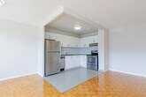 Located at 380 Gibb St in Oshawa, Ontario, this 2-bedroom, 1-bathroom unit offers a well-organized, single-floor layout designed for comfortable everyday living. Warm parquet flooring flows consistently throughout the living areas and bedrooms, lending a classic and cohesive look to the space.

The open kitchen connects seamlessly to the living room and features white cabinetry with sleek bar-pull hardware, stone-look countertops, a white subway tile backsplash, and stainless steel appliances including a refrigerator, electric range with over-the-range ventilation, and dishwasher. Light tile flooring completes the kitchen's clean aesthetic.

The spacious living room is bathed in natural light from large windows that frame views of the surrounding neighbourhood, supported by baseboard heating along the perimeter. The primary bedroom is generously sized and includes a dedicated closet with built-in shelving and hanging rods, while the second bedroom also benefits from a bright window and parquet flooring.

The bathroom is finished with white subway tile surrounding a full soaker tub and shower combination, maintaining the unit's consistent, clean design. A dedicated entry closet with sliding doors provides additional storage near the front door. Neutral wall tones throughout enhance the bright and airy ambiance of the unit.