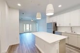 Located at 25 Silver Moon Circle in St. Augustine, FL, this thoughtfully designed single-floor residence offers 2 bedrooms, 2 bathrooms, and a well-organized layout with generous storage throughout. The open-concept kitchen and living area serves as the heart of the home, anchored by a large white quartz-topped center island illuminated by modern pendant lights. Crisp white cabinetry reaches to the ceiling, complemented by a full suite of stainless steel appliances including a refrigerator, range, microwave, and dishwasher. Wood-look plank flooring flows seamlessly through the main living space, which features a ceiling fan and French doors that invite natural light. The primary bedroom is a spacious retreat with a ceiling fan, large windows offering outdoor views, and access to well-appointed closets with wire shelving systems — five closets total serve the residence. The bathrooms are clean and contemporary, featuring tile flooring, glass-enclosed showers with tile surrounds, and modern vanities with ample drawer storage. Additional practical spaces include a dedicated laundry area and a utility room. The overall ambiance is bright, clean, and move-in ready, with a neutral palette and modern finishes throughout.
