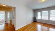 Located at 119 W Wyoming Avenue in Melrose, MA, this single-floor unit offers a well-maintained layout with classic New England character throughout. Gleaming hardwood floors extend across the living areas and bedrooms, reflecting natural light and adding warmth to the overall aesthetic.

The living room is a bright, open space featuring a classic cast-iron radiator beneath double windows that allow generous natural light to fill the room. Clean white walls and crisp white baseboards create a fresh, neutral backdrop throughout the unit.

The bedrooms continue the hardwood flooring and share the same clean, understated design. White panel doors and ample wall space provide versatility for furniture arrangement. One bedroom also features a cast-iron radiator positioned beneath a window, ensuring consistent warmth.

The galley kitchen is well-appointed with white cabinetry, dark granite countertops, a stainless steel sink, a gas range with oven, and a stainless steel refrigerator. Tile flooring and an under-cabinet range hood complete the functional layout, offering efficient use of space for cooking and storage.

The bathroom features classic white subway tile lining the walls of the tub surround, a pedestal-style sink, chrome fixtures, and a window that brings in natural light and ventilation, contributing to a clean, timeless feel.