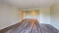 Located at Abbeyville Road in Pittsburgh, PA 15228, this one-bedroom, one-bathroom unit offers a well-organized layout across a single floor. The open living area features durable hardwood-style plank flooring and a textured ceiling, creating a clean and neutral aesthetic. A large sliding glass door fills the space with natural light and provides direct access to a private balcony, offering pleasant outdoor views. The kitchen is positioned adjacent to the living area and includes white cabinetry, a range, and a practical pass-through design that maintains a connected feel throughout the main living space. The generously sized bedroom is carpeted for comfort, featuring a textured ceiling, a window with outdoor views, and two doorways — one leading to the hallway and another to a dedicated walk-in closet. The walk-in closet provides ample storage with double hanging rods and carpeted flooring. The full bathroom is finished with wood-style flooring, a white vanity with under-cabinet storage, a toilet, and a tub/shower combination with a curtain rod. Throughout the unit, neutral tones and clean finishes contribute to a move-in-ready atmosphere that is both functional and easy to personalize.
