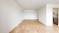 Located on the fourth floor at 1255 Birchmount Road in Toronto, this well-appointed one-bedroom, one-bathroom unit offers a clean, modern aesthetic throughout. Light wood laminate flooring runs seamlessly across the living room, bedroom, and hallway, creating a warm and cohesive feel. The open living room is generously proportioned, filled with natural light from a wide bank of windows that frame views of the surrounding neighbourhood and treeline. A textured ceiling adds a classic character to the space. The kitchen is thoughtfully designed with white cabinetry, a white subway tile backsplash, grey laminate countertops, a double stainless steel sink, and stainless steel appliances including a full-size refrigerator and dishwasher. The bedroom is a comfortable size, featuring a large window with outdoor views, a built-in sliding-door closet, and baseboard heating. The bathroom is finished with white subway tile surrounding the bathtub and shower, neutral stone-look floor tiles, a modern vanity with a white basin, and chrome fixtures. The unit is bright, clean, and move-in ready, offering a practical and comfortable layout ideal for single occupants or couples.