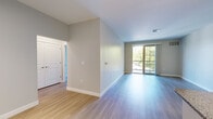 Located at 60 Traders Row in Salem, MA, this well-appointed two-bedroom, two-bathroom residence offers a thoughtfully designed single-floor layout. The open-concept living and kitchen area sets the tone with light hardwood-style flooring, neutral walls, and a sliding glass door that leads to a private balcony, flooding the space with natural light and providing outdoor views. The kitchen features granite countertops with a breakfast bar overhang, white cabinetry, stainless steel appliances, pendant lighting, and track lighting overhead. The spacious primary bedroom is carpeted for comfort and includes direct access to a well-finished en-suite bathroom with a granite-topped vanity, tile flooring, and ample cabinetry. The second bedroom, also carpeted, benefits from a large window that brings in generous natural light. A second full bathroom mirrors the quality finishes of the first, complete with a tub-shower combination, tile floors, and a granite vanity. Two hallways provide smooth connectivity throughout the unit, while a dedicated closet adds convenient storage. Clean lines, consistent neutral tones, and quality finishes throughout create a cohesive and inviting atmosphere suited for modern living.