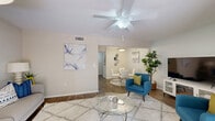 Located in Largo, Florida, this single-story, 2-bedroom, 1-bathroom home offers a thoughtfully organized layout across a comfortable footprint. The living room serves as the heart of the home, featuring wood-look flooring, a ceiling fan, a fireplace unit, and sliding glass doors that open to a private outdoor patio, allowing natural light and lush greenery views to fill the space. Adjacent to the living room, a dedicated dining area connects seamlessly to the galley-style kitchen, which is equipped with warm wood cabinetry, granite-style countertops, a full suite of white appliances, and a stainless steel sink — all tied together with matching wood-look flooring. The primary bedroom is generously sized, featuring plush carpeting, a ceiling fan, a large window with outdoor views, and convenient closet access. The second bedroom also features carpeting and a ceiling fan, with its own closet. The bathroom is clean and functional, offering a shower-tub combination with a curtain, wood-look flooring, and a bright, neutral palette. A hallway connects the rooms efficiently, completing this well-structured and move-in-ready home in the heart of Pinellas County.